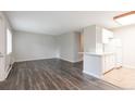Well-lit living room with hardwood floors and view of kitchen with breakfast bar at 5770 E Warren Ave # 206, Denver, CO 80222