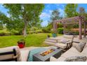 Cozy backyard patio features comfortable seating, a modern fire pit, and scenic views at 2061 Chesapeake Pl, Highlands Ranch, CO 80126