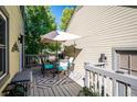 Deck with outdoor dining set, umbrella, and gray patterned rug at 6324 S Grape Ct, Centennial, CO 80121