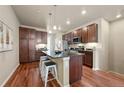 Modern kitchen with a granite island, dark wood cabinets, and stainless steel appliances at 8421 Galvani Trl # E, Littleton, CO 80129