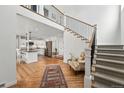 Bright, open foyer with staircase, hardwood floors, and view into a modern, well-equipped kitchen at 1220 S Elm St, Denver, CO 80246