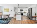 Bright kitchen with a marble island, white cabinetry, modern appliances, and adjacent dining space at 1220 S Elm St, Denver, CO 80246