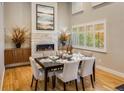 Elegant dining room featuring a stone fireplace, hardwood floors, and large window letting in natural light at 1231 Cedar Ave, Boulder, CO 80304