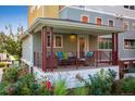 Relax on this charming front porch, featuring comfortable seating and colorful pillows overlooking beautiful landscaping at 1231 Cedar Ave, Boulder, CO 80304