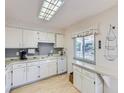 Cozy kitchen featuring white cabinets, wood floors, and a bright window at 1576 S Ursula Ct, Aurora, CO 80012