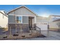 New construction home with gray siding, stone accents, and a two-car garage at 1386 Bloom St, Brighton, CO 80601