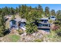 Mountain home nestled on a rocky cliffside with mature trees providing privacy at 22598 Westview Ave, Golden, CO 80401