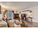Cozy living room features a brick fireplace, wood floors, and access to an outdoor patio at 3141 S Tamarac Dr # 110G, Denver, CO 80231