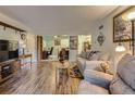 Living room showcasing wood floors and an open floor plan leading to office, dining, and kitchen areas at 3141 S Tamarac Dr # 110G, Denver, CO 80231