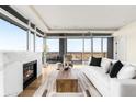 Open living room with hardwood floors, a modern fireplace, and expansive windows overlooking the cityscape at 2001 Lincoln St # 3121, Denver, CO 80202