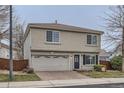 Two-story home with a brick driveway, gray stucco, tile roof, and attached two car garage at 20000 E Mitchell Pl # 39, Denver, CO 80249