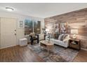 Bright living room with wood-paneled accent wall, stylish decor, and ample natural light at 1935 W 102Nd Ave, Thornton, CO 80260