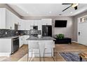 Open concept kitchen with modern white cabinets, granite countertops, stainless steel appliances, and breakfast bar at 2508 Kensing Ct, Denver, CO 80211