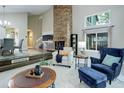 Inviting living room featuring a brick fireplace and large windows at 10966 W Half Moon Pass, Littleton, CO 80127