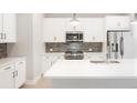 Modern kitchen design with white cabinetry, stainless steel appliances, and stylish backsplash at 20968 E 60Th Pl, Aurora, CO 80019