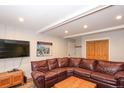 Comfortable living room with a large leather sectional sofa and a mounted television at 805 Columbine Rd # 105, Breckenridge, CO 80424
