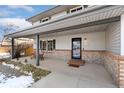 Inviting front porch features exposed brick detail, seating and a welcome mat at 11936 W Temple Dr, Morrison, CO 80465