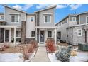 Two-story townhome with gray siding, stone accents, and a landscaped front yard at 17217 E Exposition Dr, Aurora, CO 80017