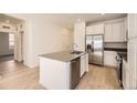 Modern kitchen with white cabinets, stainless steel appliances and an island at 5015 N Quemoy St, Aurora, CO 80019