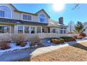 Tan two-story townhome with white trim, small fenced yard, and snow on ground at 1176 E 130Th Ave # C, Thornton, CO 80241