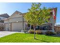 Beautifully landscaped front yard with a charming porch and craftsman-style details at 697 Gamble Oak St, Brighton, CO 80601