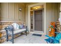 Inviting front porch featuring a comfortable bench with decorative pillows and charming decorative accent at 25015 E Park Crescent Dr, Aurora, CO 80016