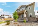 Inviting two-story home with a charming front porch, complemented by a well-manicured lawn and a lovely shade tree at 21492 E 60Th Ave, Aurora, CO 80019