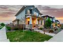 Two-story home with a welcoming front porch, well-maintained lawn, and landscaped yard, perfect for enjoying outdoor living at 21492 E 60Th Ave, Aurora, CO 80019