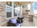 Relaxing front porch showcasing cozy seating, brick accents, and providing a charming spot for outdoor enjoyment at 21492 E 60Th Ave, Aurora, CO 80019