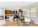 Open kitchen and dining area with stainless steel appliances and stylish pendant lighting at 5514 Uinta St, Denver, CO 80238