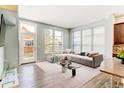 Bright living room with modern gray sofa, plush rug, and abundant natural light at 5514 Uinta St, Denver, CO 80238