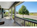 Covered porch with gray painted railings showcases the neighborhood street view at 5514 Uinta St, Denver, CO 80238