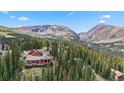 Beautiful mountain home with a deck surrounded by lush trees and breathtaking mountain views at 384 Camron Ln, Breckenridge, CO 80424