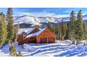 Charming mountain home with a two-car garage surrounded by snow covered trees at 384 Camron Ln, Breckenridge, CO 80424