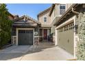 Charming two-story home featuring a well-manicured lawn, beautiful trees, and a three-car garage, all beneath a clear blue sky at 10681 Sundial Rim Rd, Highlands Ranch, CO 80126