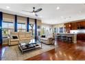 Spacious living room featuring hardwood floors, a ceiling fan, and an open layout that flows into the kitchen at 10681 Sundial Rim Rd, Highlands Ranch, CO 80126