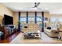 Spacious living room with hardwood floors, large windows with blue curtains, and comfortable seating at 10681 Sundial Rim Rd, Highlands Ranch, CO 80126