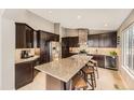 Gourmet kitchen featuring a granite island, stainless steel appliances, and modern cabinetry at 17059 Motsenbocker Way, Parker, CO 80134