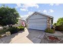 This home showcases a two-car garage and a well-maintained driveway, set against a blue sky backdrop at 607 Branding Iron Ln, Castle Rock, CO 80104
