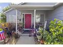 Inviting front porch with a red door, stone accents, and ample space for seating and plants at 607 Branding Iron Ln, Castle Rock, CO 80104