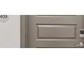View of the front door with a modern door knob and a wall that has a number plate reading 409 at 487 Interlocken Blvd # 409, Broomfield, CO 80021