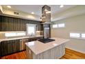 Bright kitchen featuring stainless steel appliances, a center island cooktop, and hardwood flooring at 3404 W 18Th Ave, Denver, CO 80204