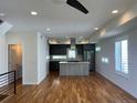 This living room features an open floor plan connected to a modern kitchen and hardwood floors at 3404 W 18Th Ave, Denver, CO 80204