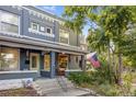 Charming painted brick duplex with a covered front porch, American flag, and landscaped front yard at 249 S Lincoln St, Denver, CO 80209