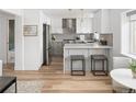 Modern kitchen features white cabinets, quartz countertops, stainless steel appliances, and breakfast bar seating at 1755 Ingalls St, Lakewood, CO 80214