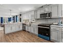 Open concept kitchen featuring gray cabinetry, stainless appliances and an island at 5202 Reed St, Arvada, CO 80002