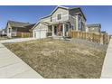 Charming two-story home featuring a front yard and three-car garage with beautiful curb appeal at 5995 Fencerow Pl, Brighton, CO 80601