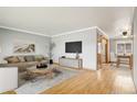 Bright living room with hardwood floors, neutral walls, and modern decor, seamlessly flowing into the dining area at 6086 W Arizona Ave, Lakewood, CO 80232