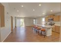 Bright, open-concept living area flows into a kitchen with a breakfast bar and wood floors at 20194 Robins Dr, Denver, CO 80249