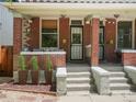 Inviting front porch with potted plants, a seating area, and brick columns at 3914 Osage St, Denver, CO 80211